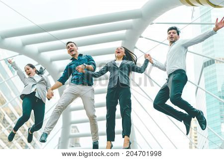 Successful business team shook hands together and jumping in the city Highly successful startup team concept of business and modern lifestyle.