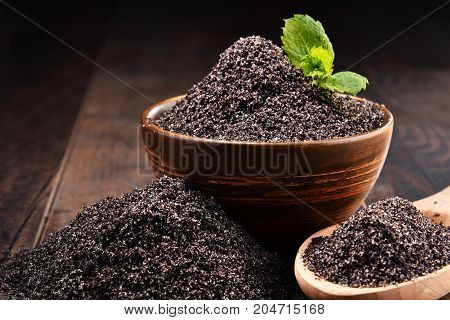 Composition With Bowl Of Poppy Seeds On Wooden Table
