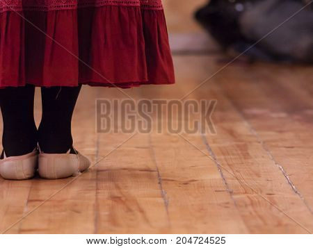 A dancer standing in a dance school room attending a lesson