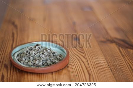 Dry Hyssop on a plate of clay, wooden table