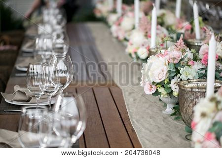 Decorated table, a plate of neatly arranged napkin, fork and knife. Beautifully decorated table with white plates, crystal glasses, linen napkin.