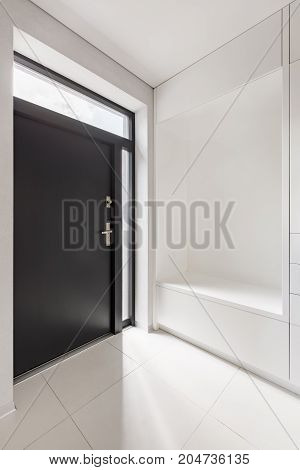 Elegant home interior with white entryway and black door
