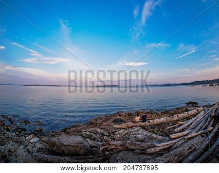 Young couple enjoying sunset view at the shore in Sidney Vancouver Island British Columbia Canada