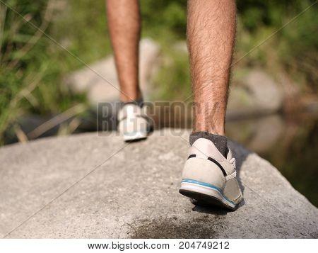 Overcoming the forest river. A man climbed out in the summer in the open air.