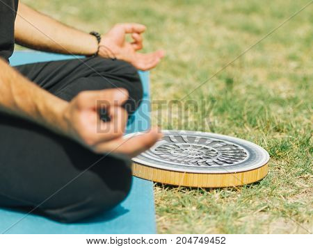 Close up of meditation athletic boy at the health club outside with personal trainer, learning the correct form.