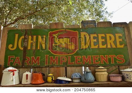 DOWNER, MINNESOTA , September 17, 2017: The old metal sign surrounded by vintage pots and pans was an advertisement product of the John Deere Corporation headquartered in Moline, Illinois.