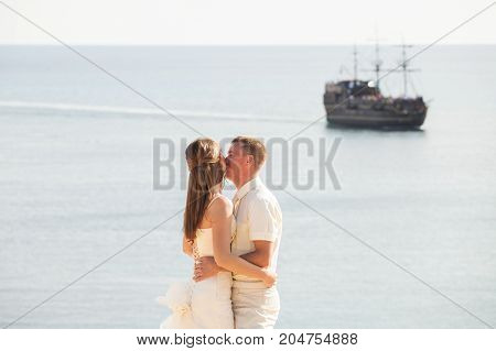 Cheerful married couple standing on the beach.