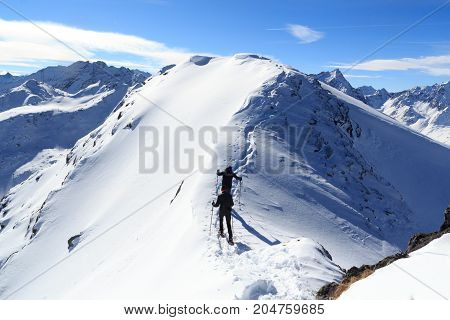 Two Men Snowshoe Hiking On Mountain Snow Arete And Panorama In Stubai Alps, Austria