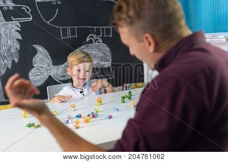 Cute little playfull toddler boy at child therapy session. Private one on one homeschooling with didactic aids.