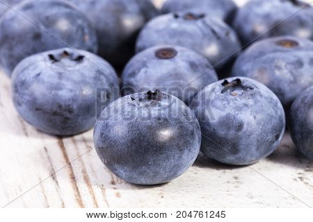 Fruits of northern highbush blueberry (Vaccinium corymbosum) on a wooden board close up