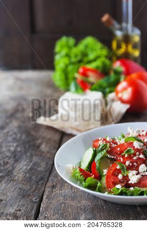 Shopska Salad In A White Plate On A Wooden Background, A Number Of Raw Ingredients Lettuce.