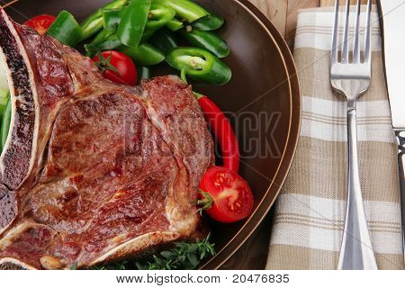 santoreggia: arrosto di manzo di ricambio rib sul piatto scuro con pepe Timo posate e pomodoro sul tavolo di legno