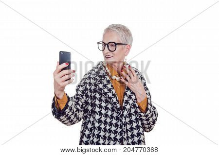 Stylish old woman in glassesmakes selfie isoladed on white.