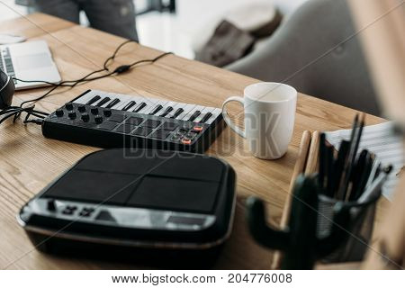 close-up view of sound producer workplace with MPC pads and cup of coffee