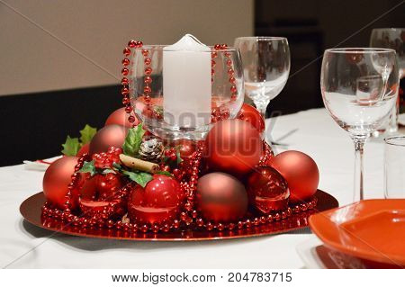 Cristhmas table in Italy with red balls, candle and pearls