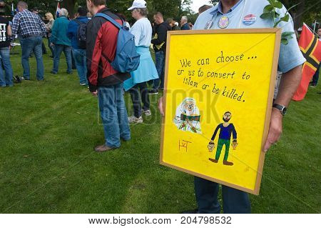 ENSCHEDE THE NETHERLANDS - SEPT 17 2017: An old man is holding a protest sign during an anti islam demonstration of Pegida. Pegida is a group of people who are against the islamization of Europe.