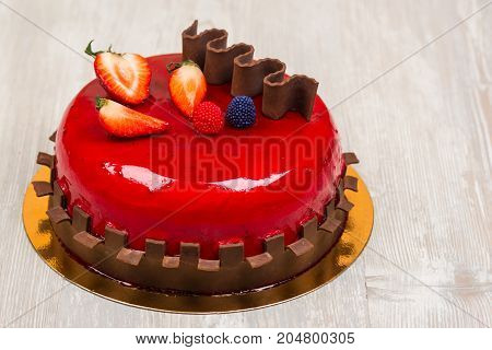 The fruit cake with chocolate on white wooden table