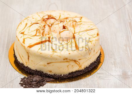 The cake with caramel and chocolate on white wooden table