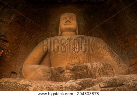 The Buddha statue in Leshan, China. The image of a man sitting in a lotus pose in a rock
