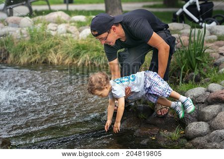 Warsaw, Poland - August 2, 2017: Dad And His Son Spend Time In The City Park.