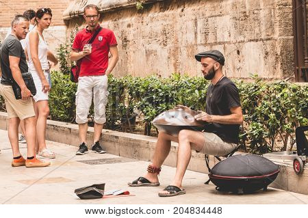 VANLENCIA SPAIN - june 16 2017: musician plays hang drum in the street and passers-by stops to listen