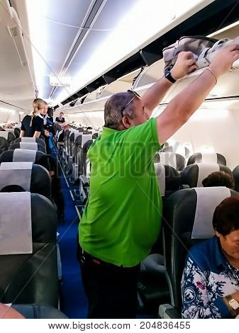 TEL AVIV ISRAEL - JULY 11 2017: Interior of modern commercial airplane with passengers on their seats waiting to taik off.