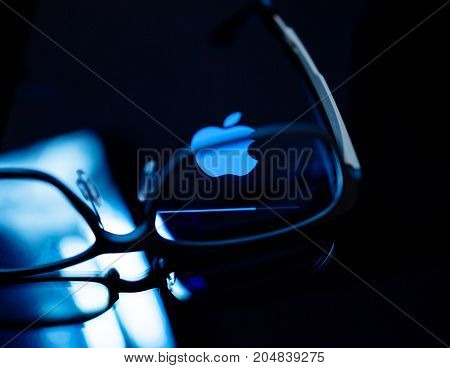 PARIS FRANCE - SEP 12 2014: Apple Computers logotype on the retina screen display of the latest iPad tablet displaying progress update loading bar through eye wear glasses