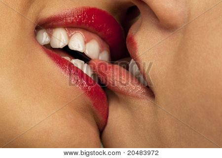 Nahaufnahme der paar Frauen Mund küssen. Eine beißen lip eine andere