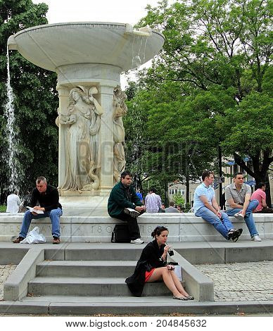 Washington DC - April 30. 2011: People relaxing in front of Daniel Chester French's marble fountain in the center of Dupont Circle