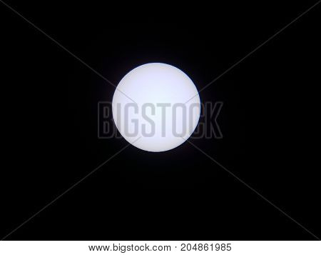 the sun viewed through a solar filter in a telescope with sunspot visible
