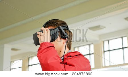 Teenager in VR headset enjoying virtual reality digital game. Virtual and augmented reality are increasingly used in human lives.