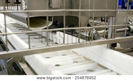 Food factory automated robotic machine. Conveyor product line for cooking and packing rations and food packs. Robotics and automatic lines used instead of human labor on factories and plants.