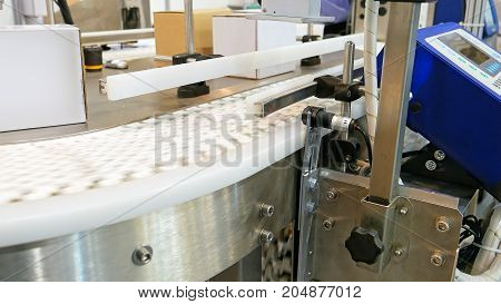 Food factory automated robotic machine. Conveyor product line for cooking and packing rations and food packs. Robotics and automatic lines used instead of human labor on factories and plants.