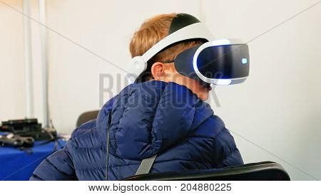Child in VR headset enjoying virtual reality digital world. Virtual and augmented reality are increasingly used in human lives.