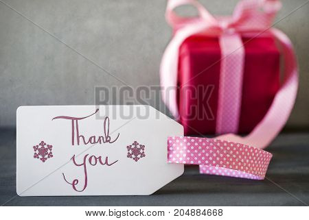 Label With English Calligraphy Thank You. Pink Present Or Gift With Gray Cement Background