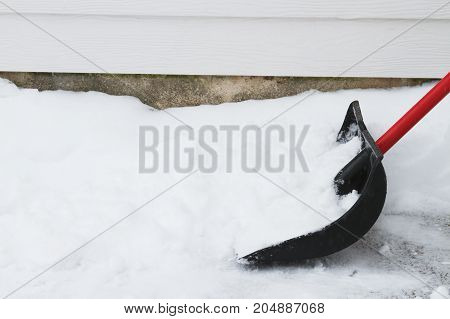 a snow shovel in the drive way.