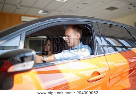 The beautiful couple chose a new car for themselves. The concept of buying a new car.