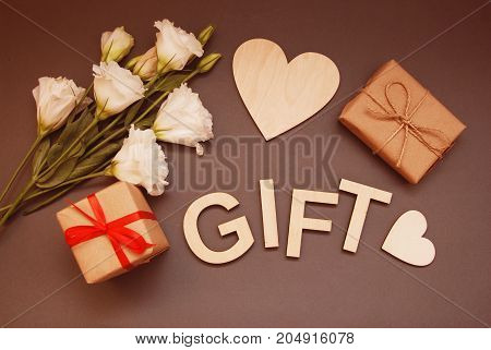 Gift box on the wooden background. Red ribbon. Valentine's Day gift.