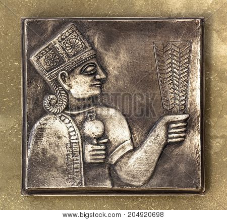 An ancient Mayan relief on bronze tablet with golden tones.