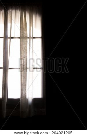 The curtain of a window which shows the light of day.