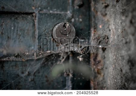 An old lock between dust and cobwebs.