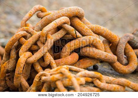 Old orangy rusty heavy iron chain, close-up