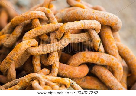 Old orangy rusty heavy iron chain, close-up