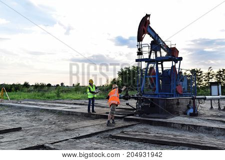 Two engineers at work on an east European oil well