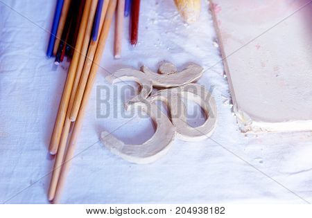 Symbol OM with clay on the desk