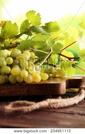 Grapes on wooden table and grape leaves . Healthy fresh fruit wine grapes.
