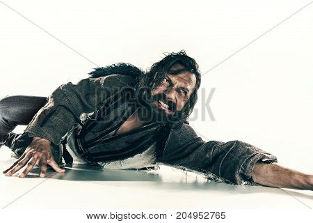 Actor in makeup, a poor man isolated on white studio background. The bum in canvas rags. concept of vagrancy and survival