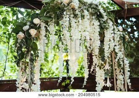 Wedding arch decorated with white hanging flowers