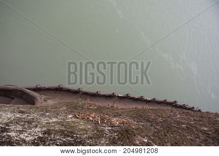 Leshan Buddha Park with chinese pagodas and  statues in Leshan, China. View from the mountain to the river. Misty river
