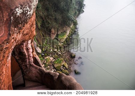 Leshan Buddha Park with chinese pagodas and  statues in Leshan, China. View from the mountain to the river. Misty river